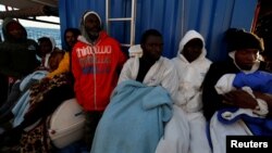FILE - Rescued migrants rest on the rescue ship Alan Kurdi, operated by German NGO Sea-Eye, during a delivery of supplies by the NGO Migrant Offshore Aid Station off the coast of Malta, April 9, 2019.