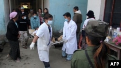 Medical staff at the Laiza hospital carry a man on a stretcher after he was injured during an artillery attack by the Burmese military in the town of Laiza, January 14, 2013. 