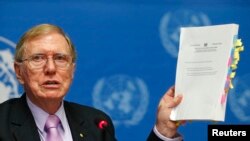 Michael Kirby, ketua Komisi Penyelidikan HAM di Korea Utara memegang laporan pada konferensi pers di Jenewa (17/2). (Reuters/Denis Balibouse)