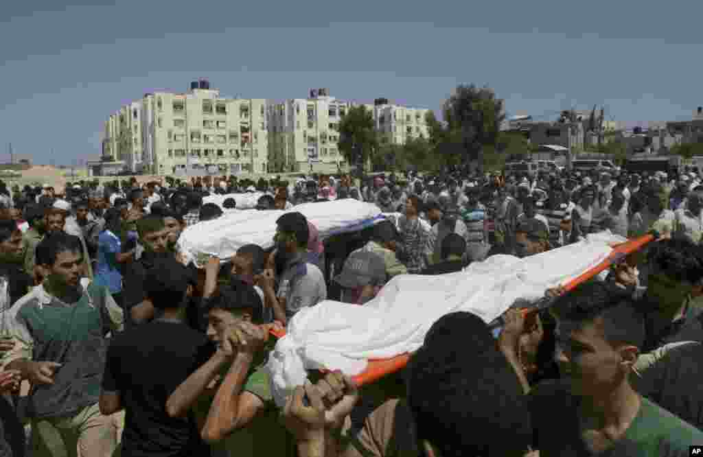 Palestinians carry bodies of 10 members of the Al Astal immediate and extended family that were killed by an Israeli strike on their homes, during their funeral in Khan Younis, southern Gaza Strip, July 30, 2014. 