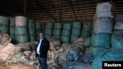 Kittisak Ratanawarahal, chairman of the Northern Farmers Network, stands in warehouse of rotten rice abandoned ten years ago in Phichit province under price-support scheme by then-prime minister Thaksin Shinawatra Feb. 6, 2014.