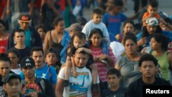 Ratusan migran asal Amerika Tengah berjalan bersama melewati perbatasan Guatemala – Meksiko, dekat Ciudad Hidalgo, Meksiko, 5 Juni 2019.
