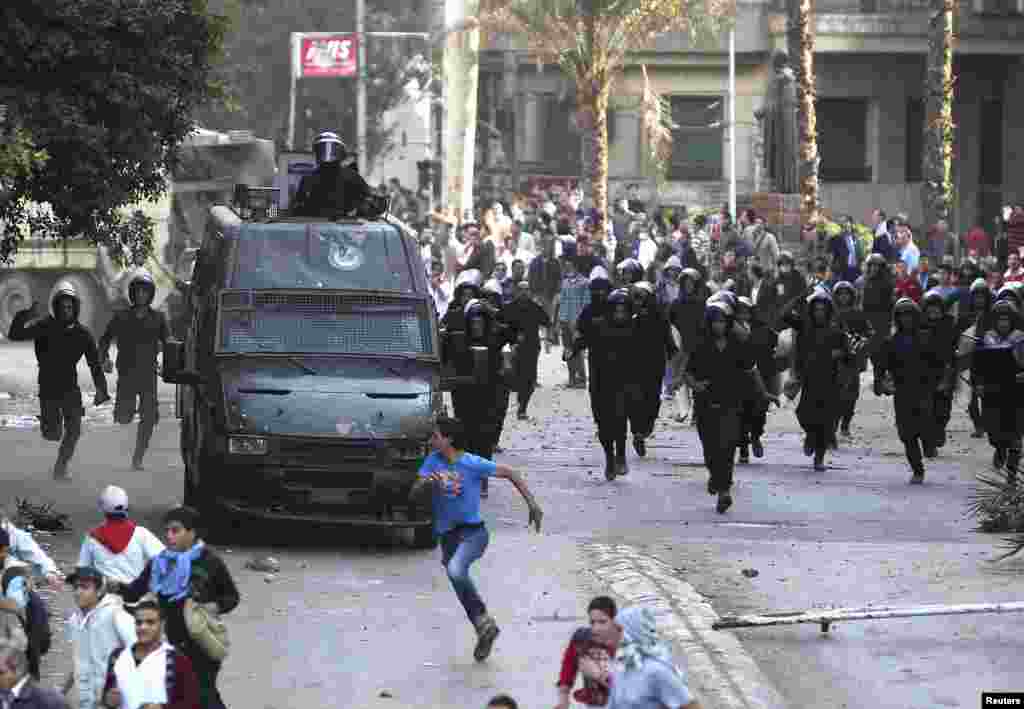 Protesters run during clashes with police near Tahrir Square, Cairo, Egypt, November 28, 2012.