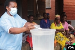 A health worker educates communities on how to mix chlorine with water as a preventive measure against spread of cholera, in Blantyre, Malawi. (Lameck Masina/VOA)
