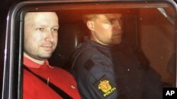 Norwegian Anders Behring Breivik (L), the man accused of a killing spree and bomb attack in Norway, sits in the rear of a vehicle as he is transported in a police convoy as he is leaving the courthouse in Oslo July 25, 2011