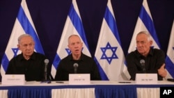FILE - From left, Israeli Prime Minister Benjamin Netanyahu, Defense Minister Yoav Gallant and Cabinet Minister Benny Gantz speak during a news conference in the Kirya military base in Tel Aviv, Oct. 28, 2023. 