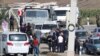 People, including Armenian service members and refugees from Nagorno-Karabakh region, gather at a checkpoint in the village of Kornidzor, Armenia, Sept. 24, 2023. 