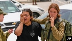 An Israeli soldier cries outside a military base following a deadly shootout in southern Israel along the Egyptian border, June 3, 2023. 