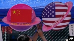 Hiasan planet berbentuk bendera China dan Amerika di Beijing pada 13 Mei 2023. Kementerian Luar Negeri China pada Kamis (2/11) mengatakan seorang pejabat tinggi dari departemen tersebut akan memimpin delegasi dalam pembicaraan nuklir China-AS.(Foto: AP)