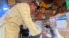 FILE - A man sells granulated sugar at his shop inside a market in Abuja, Nigeria, Oct. 27, 2023. Hundreds of people in Nigeria protested on Feb. 5, 2024, saying food costs are outpacing incomes. 