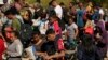 FILE - Migrants wait to be processed by U.S. Customs and Border Protection after they crossed the Rio Grande and entered the U.S. from Mexico, Oct. 19, 2023, in Eagle Pass, Texas.
