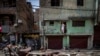 FILE - A Muslim man watches from his house after a shop was demolished in the area that saw communal violence during a Hindu religious procession in New Delhi's northwest Jahangirpuri neighborhood, in New Delhi, India, April 20, 2022.