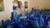 FILE - In this Aug. 12, 2024, photo, Afghan glassblower Ghulam Sakhi Saifi looks on while arranging glassware at his shop in Afghanistan's western city of Herat.