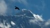 FILE - Seekor burung terbang dengan latar belakang Gunung Everest, terlihat dari Namche Bajar, distrik Solukhumbu, Nepal, 27 Mei 2019. Cheruiyot Kirui, pendaki asal Kenya, ditemukan tewas di dekat puncak gunung tertinggi di dunia.(AP/Niranjan Shrestha)