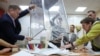 Members of a local electoral commission empty a ballot box, after polling stations closed on the final day of Russia's presidential election, in St. Petersburg, March 17, 2024.
