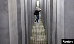 Seorang pengunjung berjalan di Holocaust Memorial to the Murdered Jews of Europe di Berlin, Jerman, 26 Januari 2024. (Foto: Reuters)