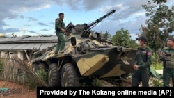 In this photo provided by the Kokang online media, members of an ethnic armed forces group known as the Three Brotherhood Alliance, check an army armored vehicle the group allegedly seized from Myanmar's army outpost on a hill in Hsenwi township in Shan state, Nov. 24, 2023.
