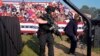 FILE - Secret Service agents surround the stage as other agents cover Republican presidential candidate former President Donald Trump at a campaign rally, July 13, 2024, in Butler, Pa.