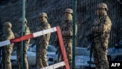 FILE - Azerbaijani servicemen stand guard at a checkpoint at the Lachin corridor, the Armenian-populated breakaway Nagorno-Karabakh region's only land link with Armenia, on Dec. 27, 2022.
