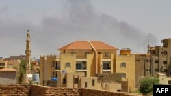 FILE - Smoke rises above buildings in Khartoum on May 12, 2023, as fighting between the forces of two rival generals continues. 