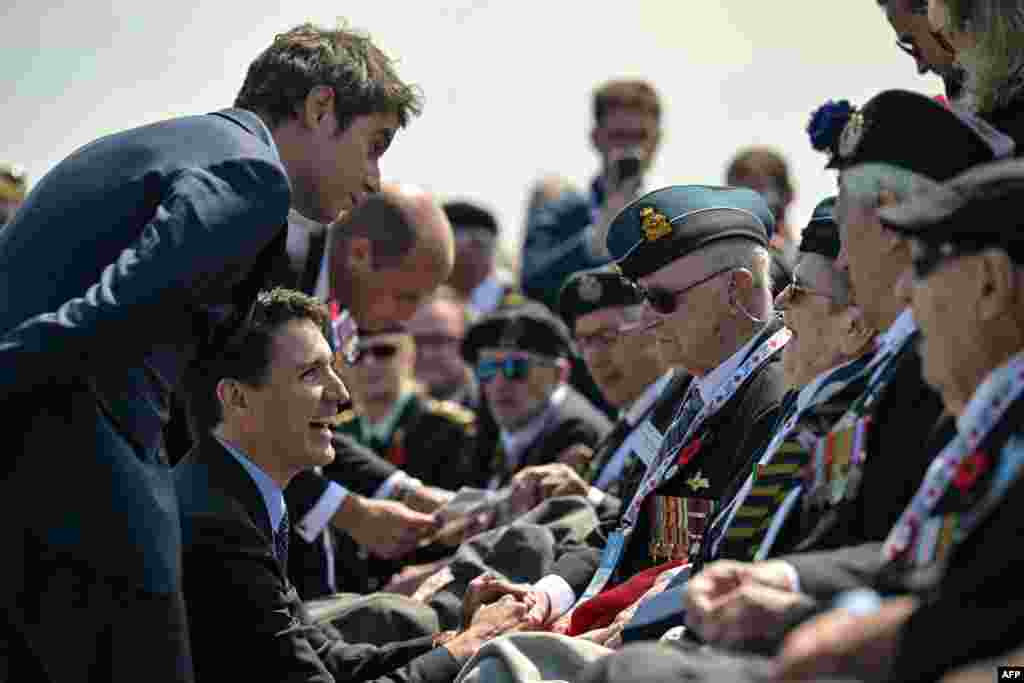 France's Prime Minister Gabriel Attal (L), Canadian Prime Minister Justin Trudeau (C) and Prince Britain's Prince William, the Prince of Wales (L) speak with WWII veterans during the Canadian commemorative ceremony marking the 80th anniversary of the World War II "D-Day" Allied landings in Normandy, at the Juno Beach Centre near the village of Courseulles-sur-Mer, in northwestern France, June 6, 2024. 