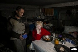 Penduduk setempat berlindung di tempat penampungan bawah tanah di desa Chasiv Yar, dekat kota Bakhmut di wilayah Donbas, di tengah invasi Rusia ke Ukraina, 5 Maret 2023. (Aris Messinis/AFP)