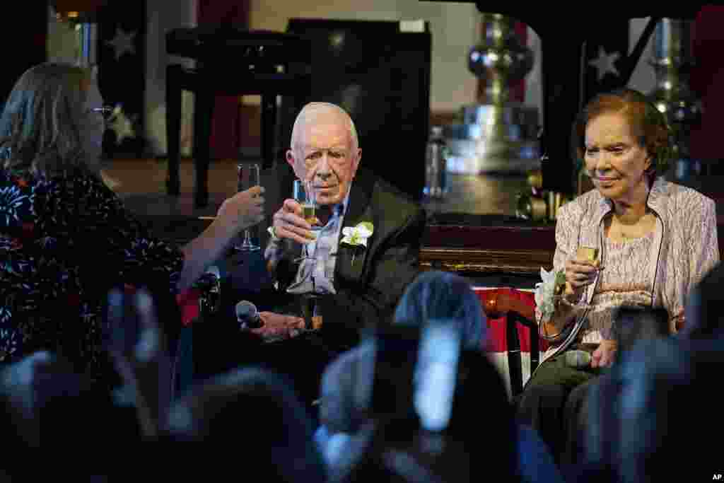 Amy Carter, left, raises her glass during a toast to her parents former President Jimmy Carter and former first lady Rosalynn Carter during a reception to celebrate their 75th wedding anniversary, July 10, 2021, in Plains, Georgia.