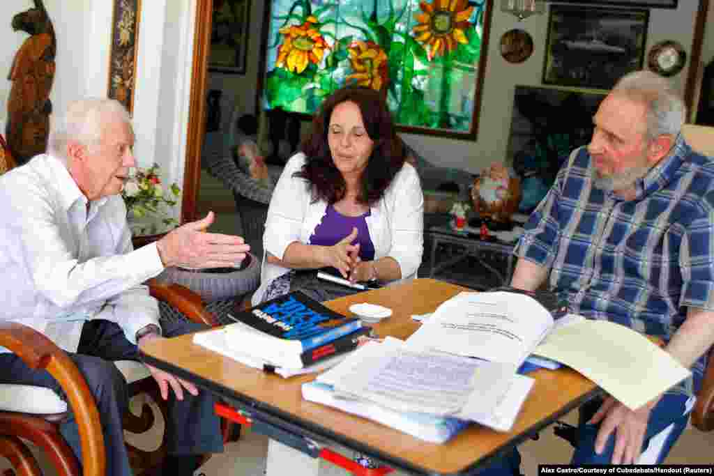 Former Cuban leader Fidel Castro and former U.S. President Jimmy Carter (L) talk during a meeting in Havana, March 30, 2011. The woman in the center is a translator.
