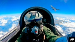 FILE - A Chinese fighter jet pilot from the People's Liberation Army (PLA) takes part in combat readiness patrol and military exercises around Taiwan, April 9, 2023, in this photo released by Xinhua News Agency.