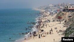 Palestinians enjoy the beach on a hot day amid the ongoing conflict between Israel and Hamas in Deir Al-Balah, in the central Gaza on April 17, 2024. (Ramadan Abed/Reuters)