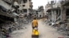 A Palestinian man pulls a boy on a cart on a street lined with destroyed buildings in Khan Yunis in the southern Gaza Strip, May 2, 2024, amid the ongoing conflict between Israel and the militant Hamas movement.