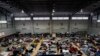 FILE - Ukrainian refugees wait in a gymnasium Tuesday, April 5, 2022, in Tijuana, Mexico.