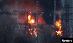 Smoke and fire are seen around high-voltage lines at a site of a Russian missile strike, amid Russia's attack on Ukraine, outside Kharkiv, Ukraine, March 22, 2024.