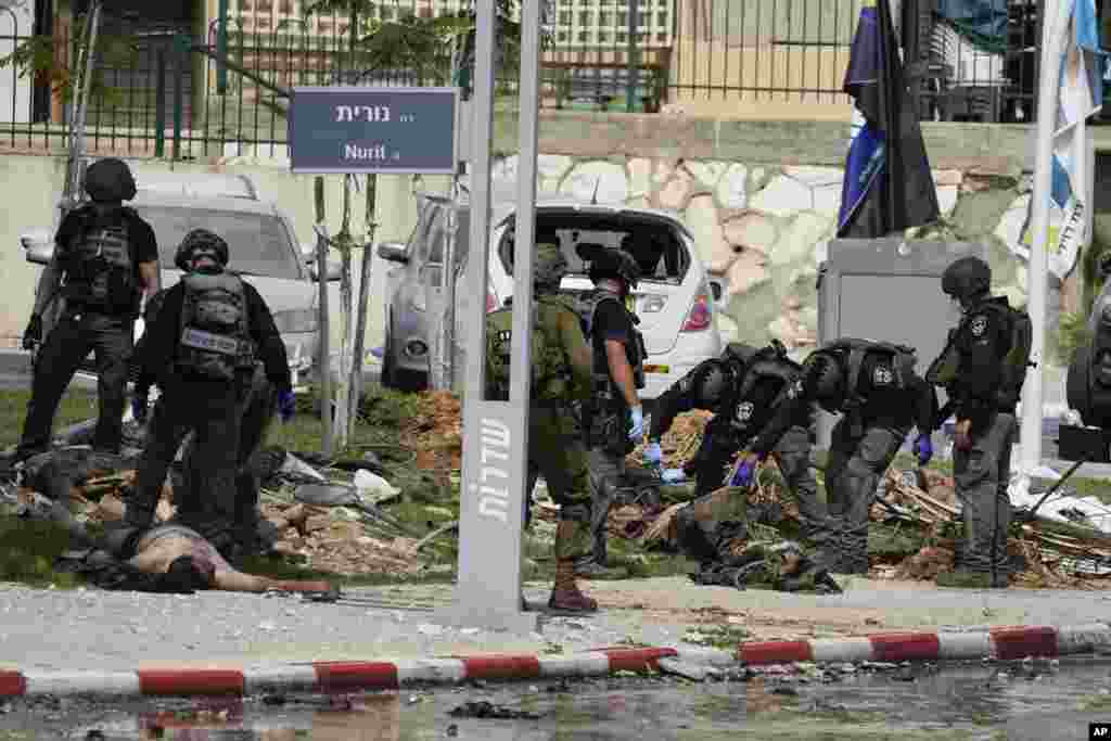 Israeli police check the bodies of militants outside the police station that was overrun by Hamas gunmen on Saturday, in Sderot, Oct.8, 2023. 
