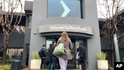 Sejumlah nasabah berdiri di luar pintu masuk Bank Silicon Valley di Santa Clara, California, Jumat, 10 Maret 2023. Lembaga Penjamin Simpanan Federal (FIDC) menyita aset-aset SVB yang menandai kebangkrutan bank terbesar sejak 2008 krisis finansial. (Foto: Jeff Chiu/AP Photo)