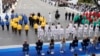 Lieutenant General and Military Governor of Paris Christophe Abad holds the Olympic flame torch on a horse as he does the torch kiss with a torch bearer during the Bastille Day military parade along the Avenue Foch, in Paris, July 14, 2024. 