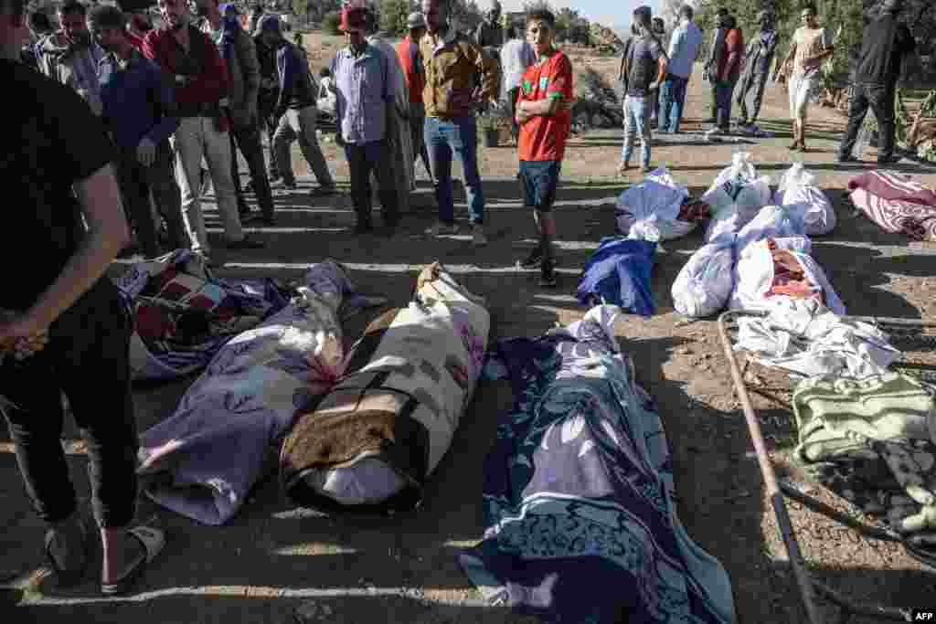 People gather around the bodies of victims of an earthquake in the mountain village of Tafeghaghte, southwest of the city of Marrakesh, Morocco, on Sept. 9, 2023.