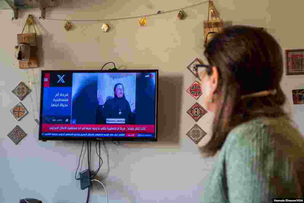 Etemad Abu Tahoun, a Palestinian mother and journalist, takes in news from Gaza, where her only son and ailing father languish. The screen reads: “A Palestinian mother’s happiness knowing that her son is alive.” Cairo, Egypt, April 1, 2024.