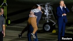 U.S. President Joe Biden looks on as Evan Gershkovich who was released from detention in Russia, is greeted by his mother Ella Milman, upon his arrival at Joint Base Andrews in Maryland, Aug. 1, 2024.