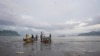 FILE - Local Cameroonian fishermen prepare fishing nets on their boats along the shores of Limbe beach, Cameroon, Apr. 12, 2022. Fishing and tourism have been temporarily suspended in coastal town of Kribi because of damage caused by ocean waters sweeping through the area.