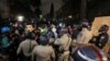 Law enforcement officers try to clear an area near an encampment by supporters of Palestinians in Gaza, on the campus of the University of California, Los Angeles (UCLA), in Los Angeles, California, in the early morning hours of May 1, 2024.
