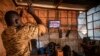 FILE - A soldier applauds the presidential inauguration of junta leader Lt. Col. Paul Henri Sandaogo Damiba during his swearing-in ceremony broadcast on national television, in Ouagadougou, Burkina Faso, Feb. 16, 2022. 