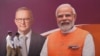 Policemen walk past a sign featuring Australian Prime Minister Anthony Albanese and Indian Prime Minister Narendra Modi in Ahmedabad, India, March 8, 2023.