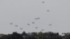Humanitarian aid falls through the sky towards the Gaza Strip after being dropped from an aircraft, amid the ongoing conflict between Israel and the Palestinian Islamist group Hamas, as seen from Israel, April 25, 2024. 