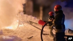 In this photo provided by the Ukrainian Emergency Service, emergency services personnel work to extinguish a fire in Ivano-Frankivsk region, Ukraine, April 27, 2024, following Russian night attacks.