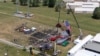 FILE - A drone view shows the stage where Republican presidential candidate and former president Donald Trump was standing during an assassination attempt the day before, and the roof of a nearby building where a gunman was shot dead, in Butler, Pennsylvania, July 14, 2024. 