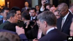 美国国防部长奥斯汀在新加坡出席香格里拉对话期间与中国国防部长李尚福握手。（2023年6月2日）