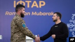 Presiden Ukraina Volodymyr Zelenskyy (kanan) memberikan penghargaan kepada seorang prajurit Muslim sebelum acara buka puasa persama di Kyiv, Ukraina, pada 7 April 2023. (Foto: AP/Efrem Lukatsky)