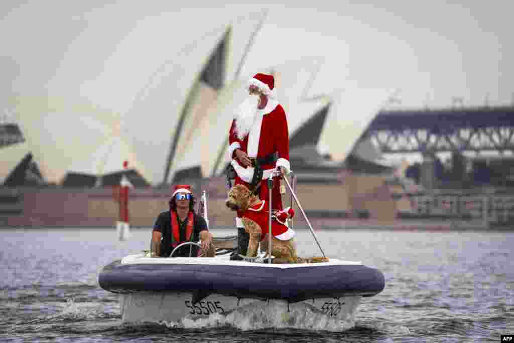 A man dressed as Santa Claus rides a boat with his dog in front of the Sydney Opera House, as part of Christmas Day celebrations for the annual Sydney to Hobart yacht race, Australia, Dec. 25, 2023.