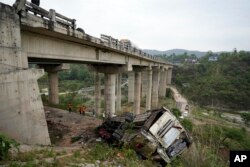 Tim penyelamat memeriksa sekitar lokasi kecelakaan sebuah bus yang membawa peziarah Hindu di ngarai Himalaya dekat Jammu, India, Selasa, 30 Mei 2023. (AP /Channi Anand)